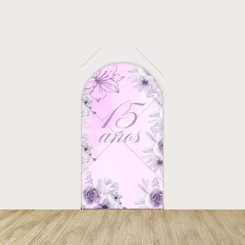 Arch panel with “15 años” elegant script in lavender surrounded by soft floral accents on a pastel pink background—perfect for Quinceañera decor.