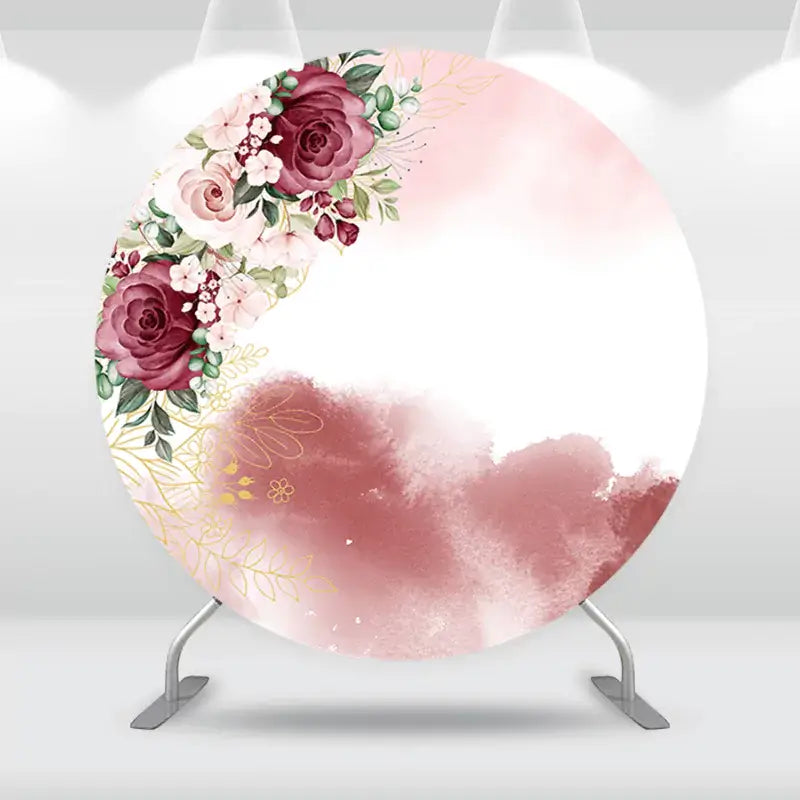 Round floral backdrop featuring burgundy roses, pink flowers, and gold leaf accents, perfect for weddings and special events.