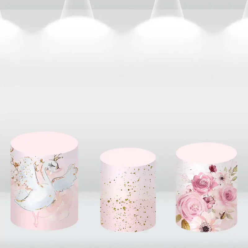 Decorative cylinder covers featuring a swan and floral designs in pink and gold, perfect for baby showers
