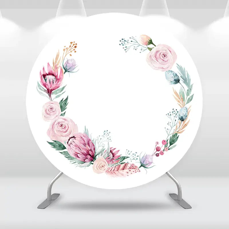 Round floral wreath backdrop featuring soft pastel pink and cream flowers arranged in a wreath design on a white background.