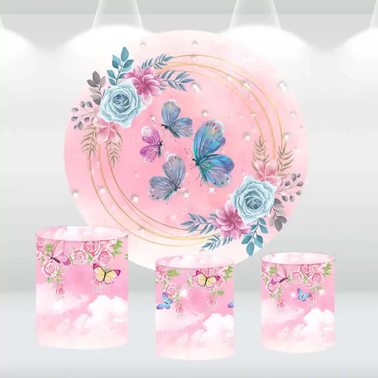 Whimsical butterfly and flower party decor set featuring a round pink backdrop and cylinder covers with delicate floral designs.