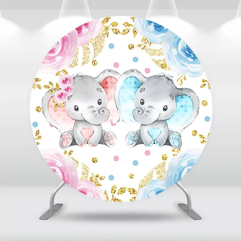 Round backdrop featuring two elephants with pink and blue accents for a gender reveal theme, surrounded by floral and gold glitter elements.