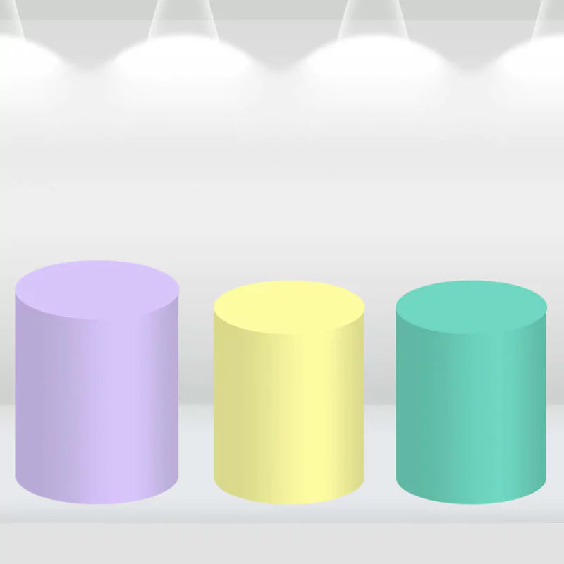 Pastel-colored cylinder covers in shades of purple, yellow, and teal, matching a unicorn-themed party decor set.