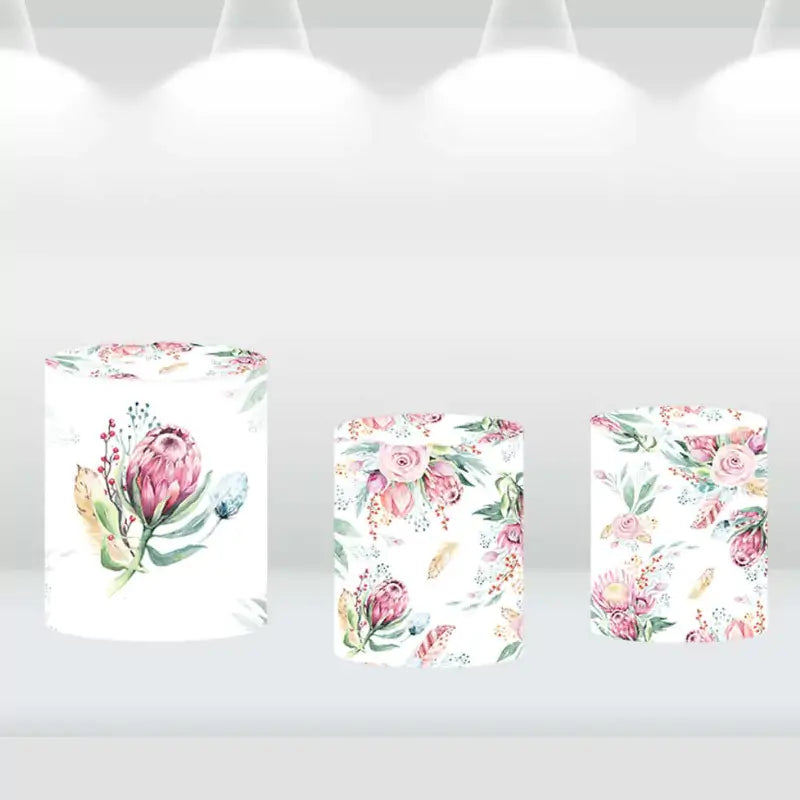 Set of three cylindrical pedestal covers with matching pastel floral designs, perfect for event décor and themed displays.