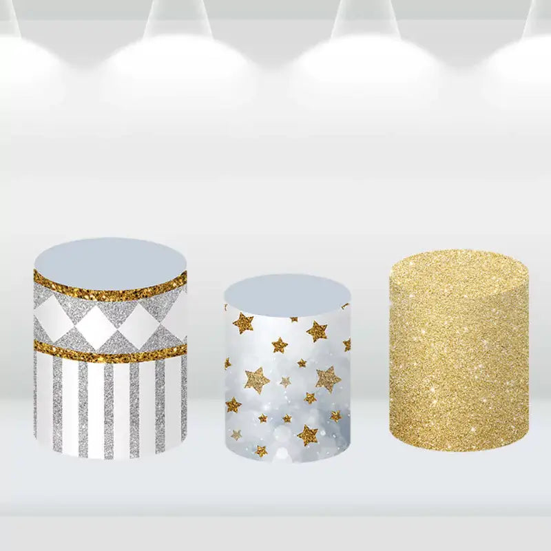 Set of three cylinder pedestal covers with gold and silver patterns, including stripes, diamonds, and glitter designs.
