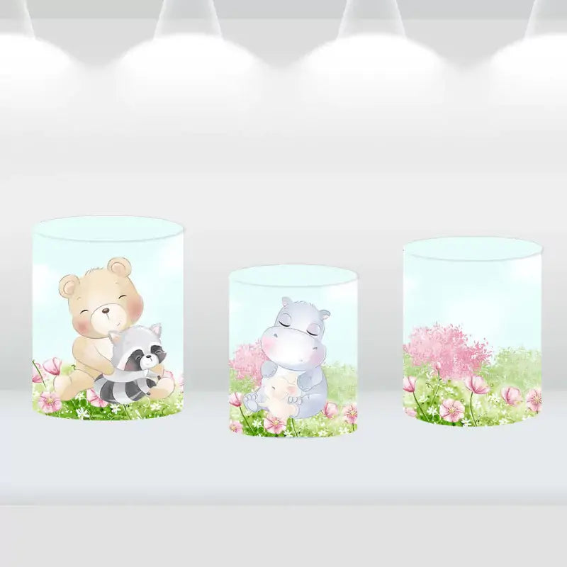 Set of three cylinder covers featuring woodland animals like a bear, raccoon, and hippo, matching the forest-themed backdrop.