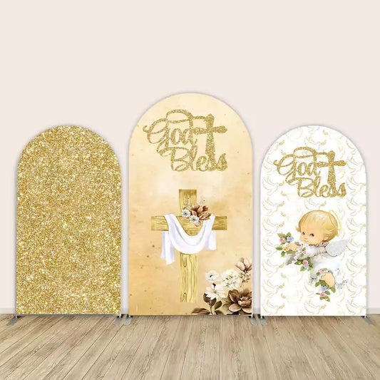 Three-piece baptism arch backdrop set with gold glitter panel, wooden cross with flowers and “God Bless” message, and angel holding flowers.
