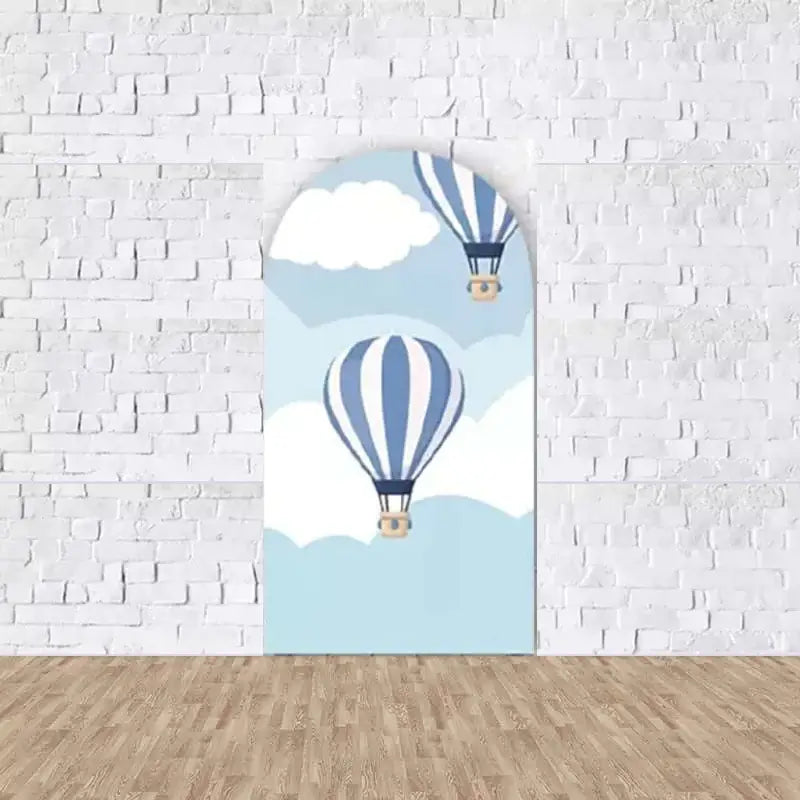 Left arched backdrop featuring vintage hot air balloons floating in a blue sky with clouds, creating a sense of freedom and adventure.
