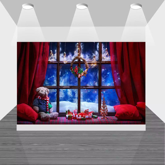 Cozy Christmas window scene backdrop with snow-covered glass, red curtains, teddy bear, plaid blanket, and holiday gifts – perfect for holiday parties and photo shoots