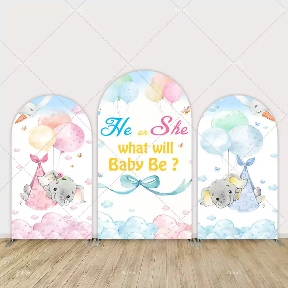 Three-panel gender reveal arch backdrop with watercolor baby elephants in stork slings, pastel balloons, clouds, and “He or She, What Will Baby Be?” text.