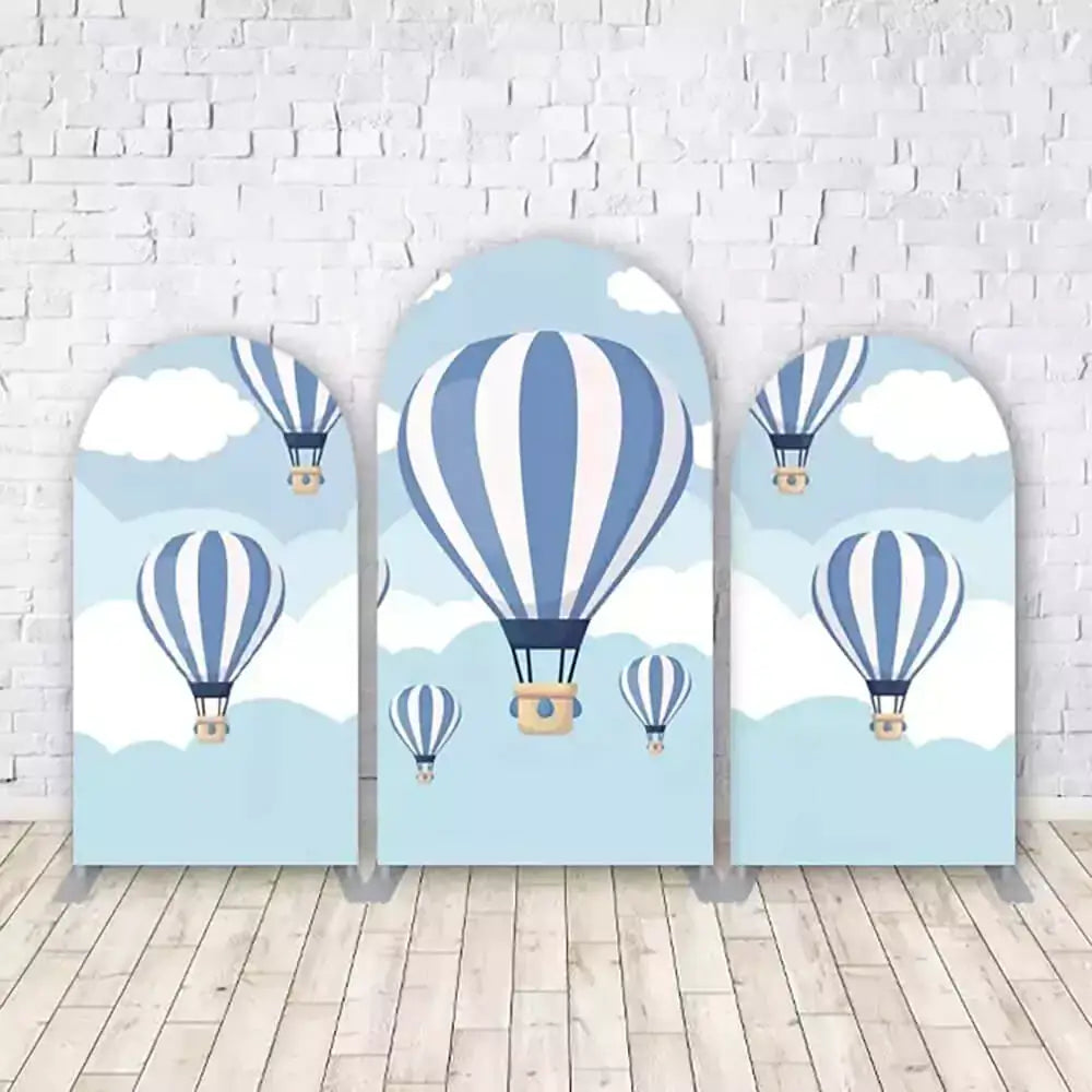 Set of three hot air balloon-themed arched backdrops with vintage hot air balloons floating in a blue sky with white clouds, perfect for adventure and travel-themed birthday parties.