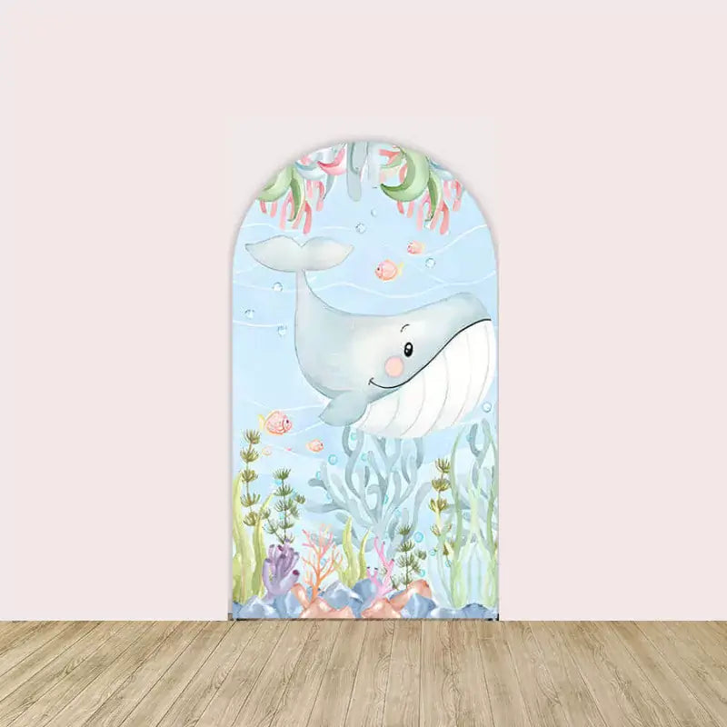 Left arch showing a smiling cartoon whale with seaweed, coral, and pink fish in an underwater setting.