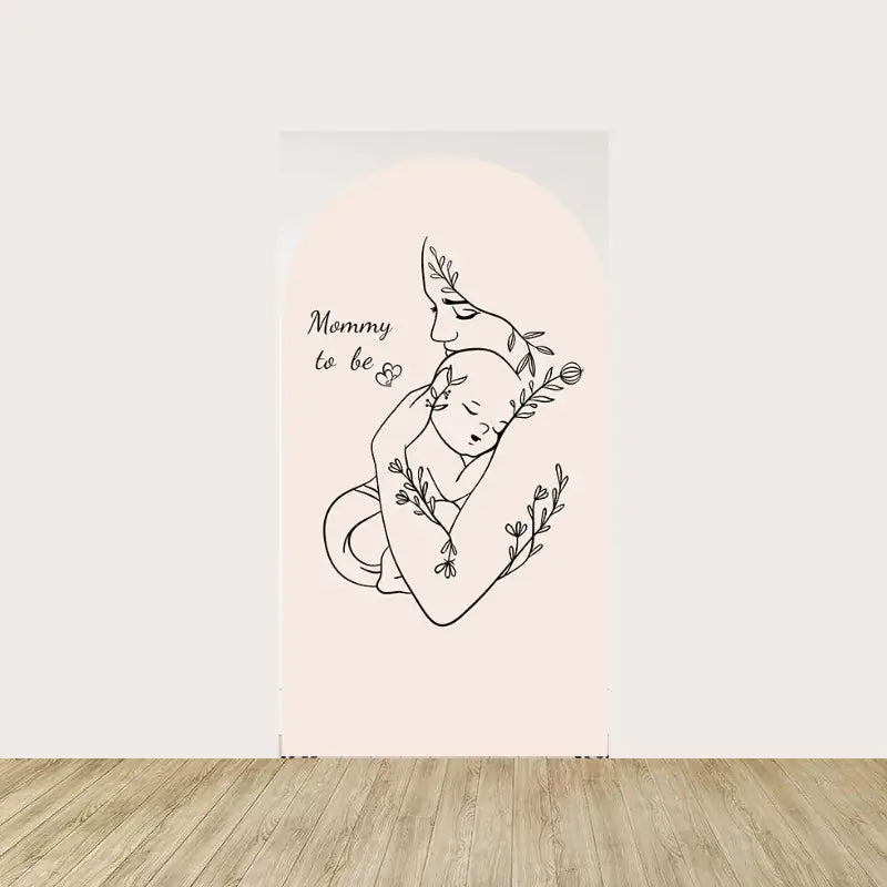 Arch panel with line art of a mom holding a sleeping baby, decorated with floral accents and “Mommy to be” text.