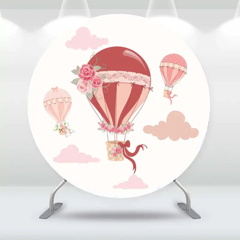 Pink hot air balloon baby shower backdrop with floral details and pastel clouds.