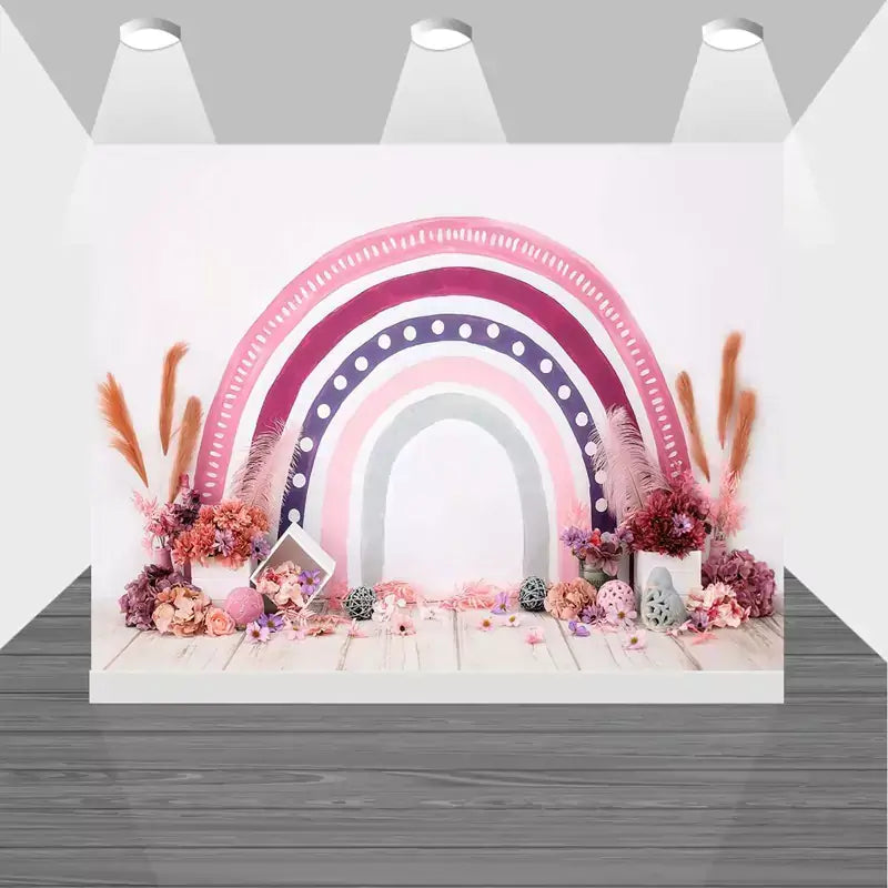 Whimsical pink rainbow backdrop featuring floral arrangements, pastel tones, and modern boho elements – ideal for feminine party decorations