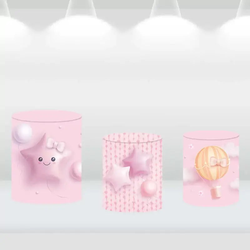 Set of three cylindrical pedestal covers with designs featuring pink stars and a hot air balloon, ideal for baby girl-themed event décor.