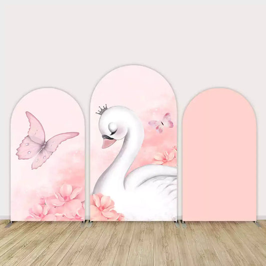 Three-piece swan-themed arch backdrop with pink background, butterflies, blush flowers, and a graceful white swan wearing a crown.