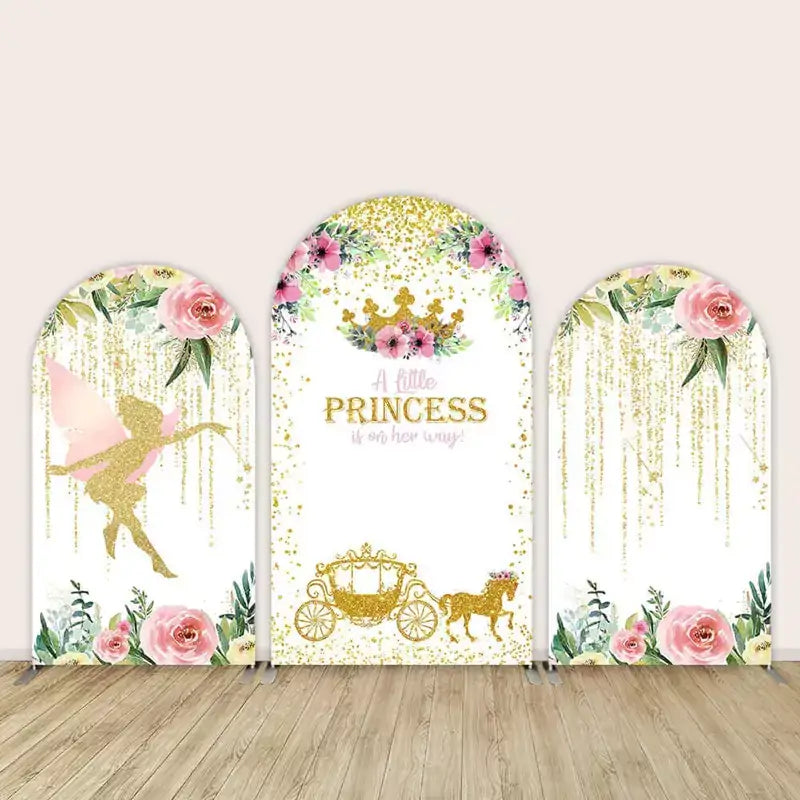 Three-panel princess baby shower arch backdrop featuring a gold fairy silhouette on one side, “A little princess is on her way” with a crown and carriage in the center, and floral drapes of gold glitter on the third arch.