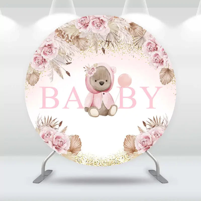Round baby shower backdrop with cute teddy bear in pink outfit, soft blush flowers, gold glitter accents, and ‘BABY’ text – perfect for baby girl celebrations