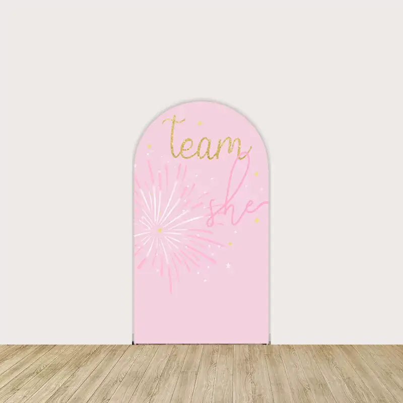 Arch panel featuring “Team She” in gold script, pink fireworks, and sparkles—perfect for baby showers and gender reveal events.