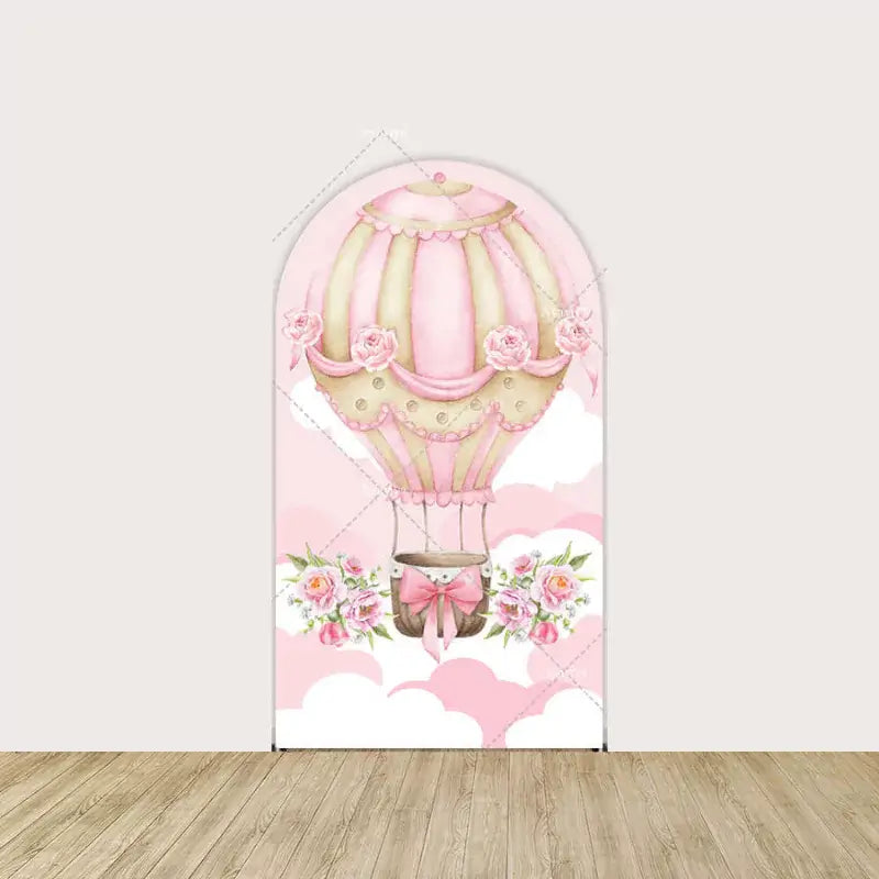 Center panel with ornate pink hot air balloon trimmed in roses and ribbons—set against a sky of white and blush pink clouds.