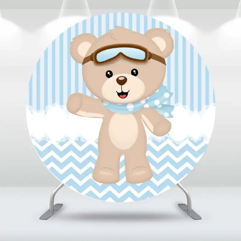 Round party backdrop featuring an adorable teddy bear in aviator gear against a blue striped and chevron pattern background.