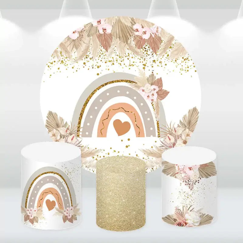 Boho-themed party decor set with a round rainbow backdrop and matching cylinder covers featuring floral and gold glitter designs.