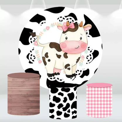 Farm animal party backdrop with cow print and matching cylinder covers for baby showers.