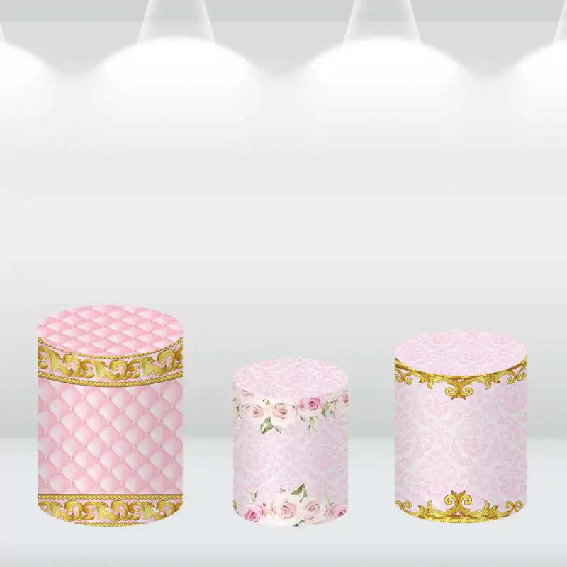 Decorative cylinder covers with pink and gold crown-themed designs, featuring quilted and floral patterns.