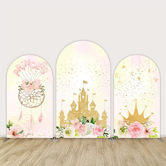 Pink and gold princess-themed arched backdrop set with a dreamcatcher, glittering castle, crown, florals, and sparkling details.