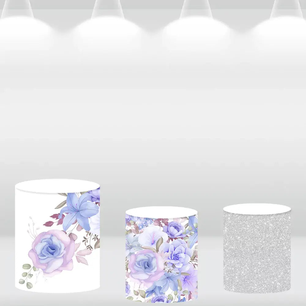 Set of three cylinder covers: one with silver glitter, one with floral patterns, and one plain white with flower accents