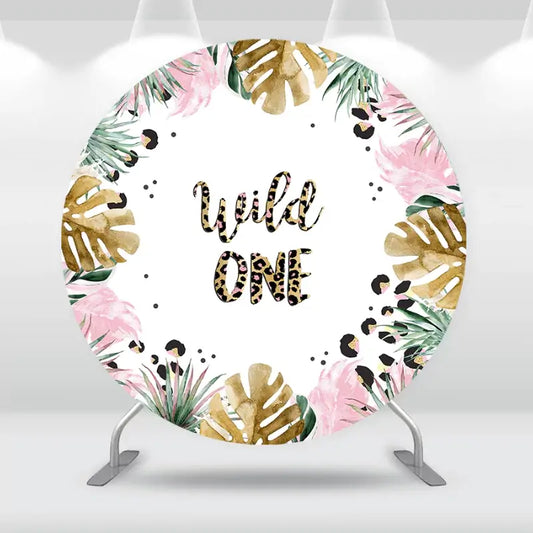 Wild One birthday party backdrop featuring tropical palm leaves, pink flowers, and leopard print text, perfect for a safari-themed celebration.