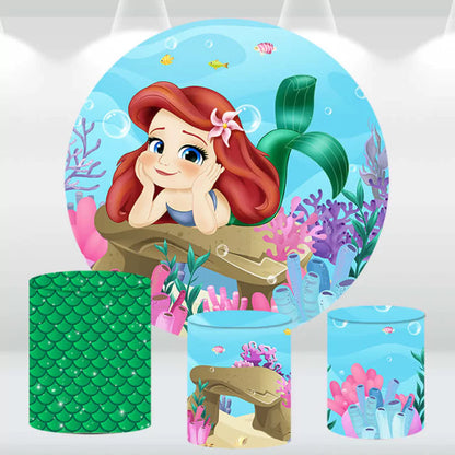 Little Mermaid-themed party backdrop with matching cylinder covers featuring an underwater scene.