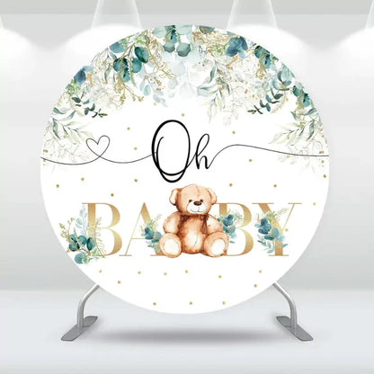 Round baby shower backdrop featuring a teddy bear, greenery, and gold accents with the words 'Oh Baby' in stylish lettering.