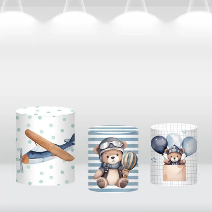 Set of three aviation-themed cylinder covers showcasing an airplane design, teddy bear with hot air balloons, and a teddy bear in a hot air balloon basket, complementing the pilot-themed backdrop.