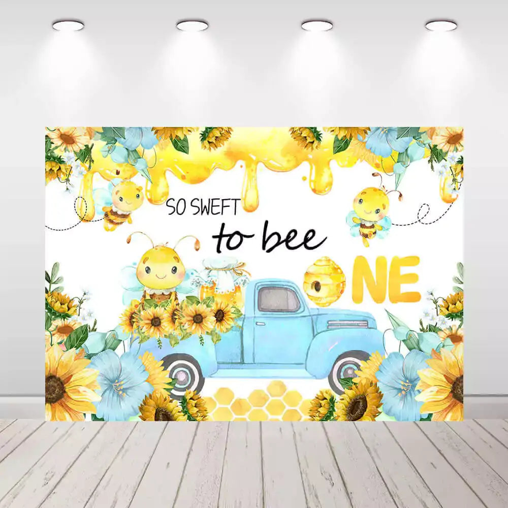 Bee-themed first birthday backdrop with "So Sweet to Bee One" text, sunflowers, and a blue truck, perfect for 1st birthday celebrations.