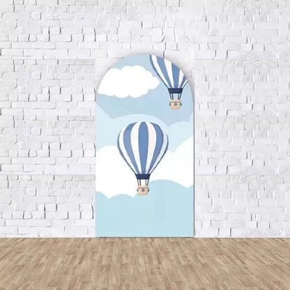 Left arch panel with striped blue hot air balloons drifting among white clouds in a light blue sky—perfect for baby shower photo backdrop.