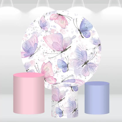 Butterfly-themed round backdrop with pastel watercolor designs and matching pink and blue cylinder covers, ideal for elegant party decorations.