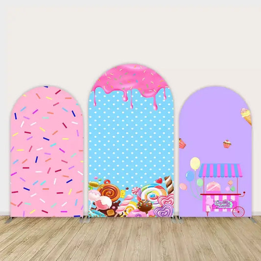 Three-panel Candyland arch backdrop featuring pink sprinkles, dripping frosting with candy, and a pastel sweet cart with cupcakes and balloons.