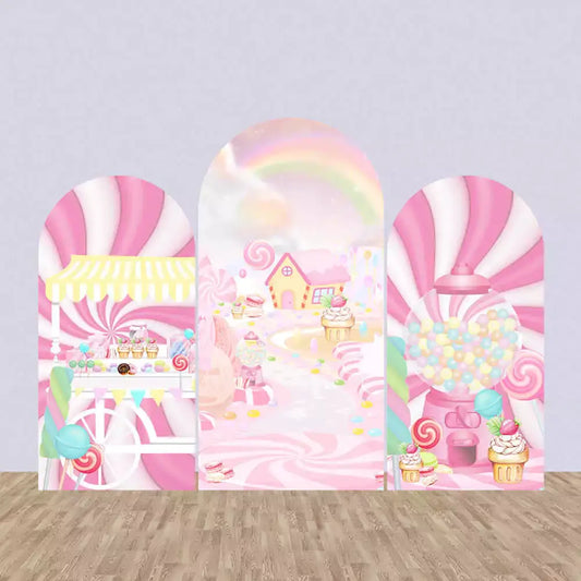 Three-panel candy-themed arch backdrop set with pink and white swirls, cupcake cart, candy house, rainbow path, and gumball machine.