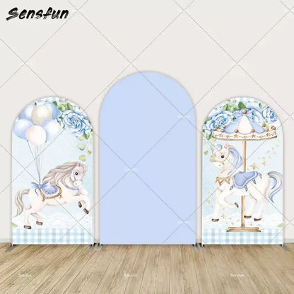 Three-panel blue arch backdrop set with carousel horse illustrations, balloons, blue roses, and gingham pattern—perfect for baby showers.
