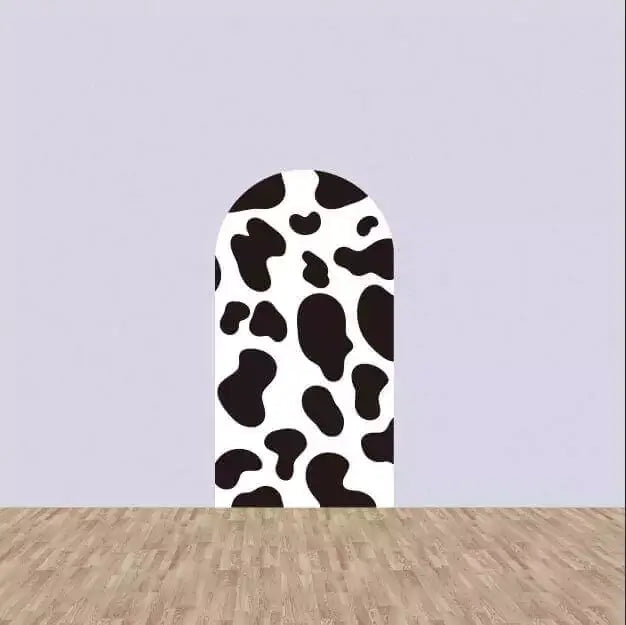 Left arch panel with bold black and white cow spots—classic farm design perfect for barnyard-themed party decor.