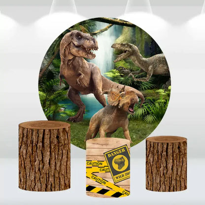 Dinosaur-themed round backdrop with lifelike dinosaurs in a jungle setting, paired with three matching cylindrical pedestal covers featuring tree log designs and a caution sign.