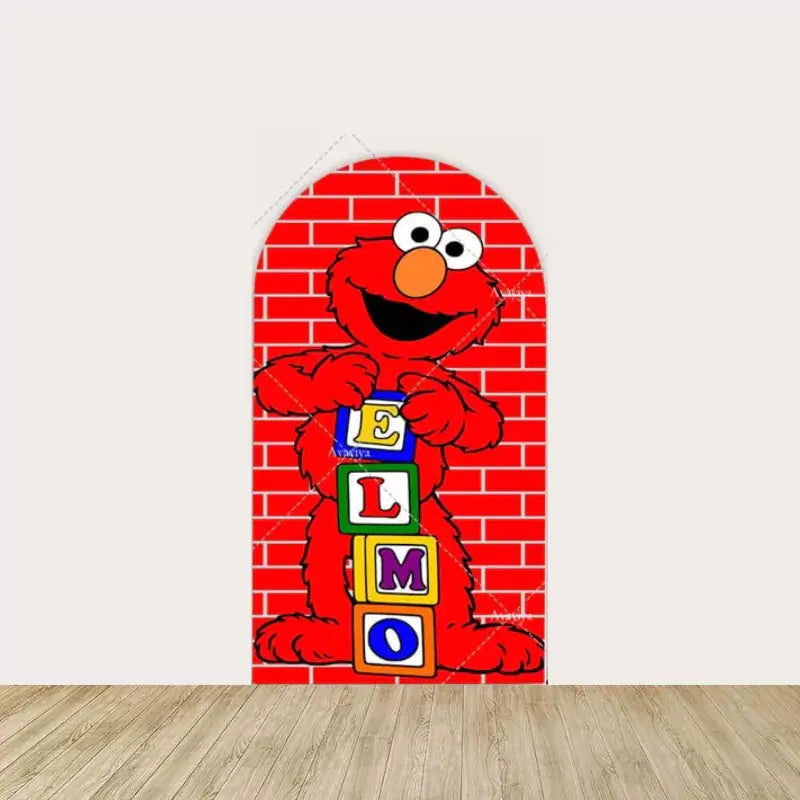 Red arched backdrop with Elmo holding colorful blocks spelling “E-L-M-O” against a brick wall, adding a playful touch to party decor.