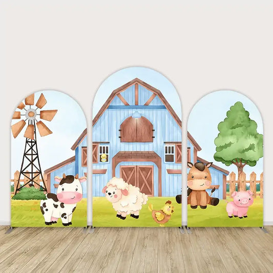 Farm-themed party backdrop with a blue barn, windmill, and barnyard animals like a cow, sheep, horse, and pig, ideal for a farm-themed birthday party