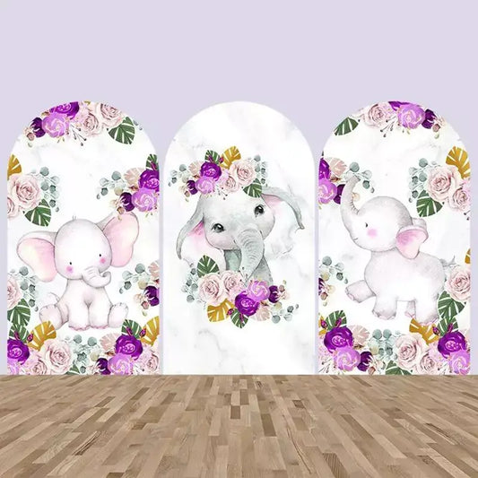 Three-piece arch backdrop with watercolor baby elephants surrounded by pink and purple roses and green leaves on a marble white background.