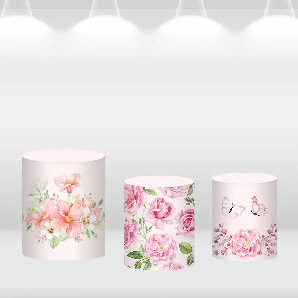 Set of three cylinder covers featuring floral designs: one with pink and white flowers, one with pink roses, and one with pink roses and butterflies, complementing the floral backdrop.