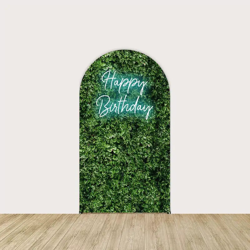 Greenery wall backdrop with “Happy Birthday” written in a neon-style font, creating a fresh, natural centerpiece for the party.