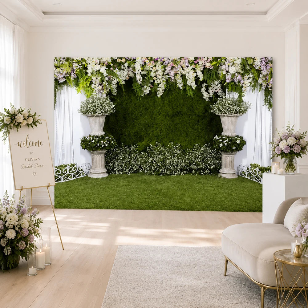 Greenery floral garden backdrop with white hanging flowers, grass wall and elegant column arrangements for weddings and bridal showers.