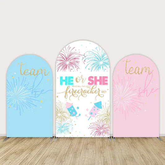 Three-panel arch backdrop set for gender reveal party featuring blue and pink fireworks, rockets, and "He or She" text with glitter-effect script.